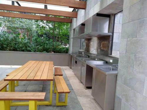 an outdoor kitchen with a wooden table and benches at L39 1Min to SouthernCross,free Gym, Pool, sunna,Tram ,Sauna in Melbourne