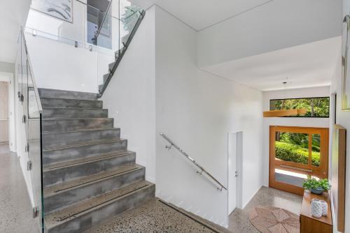 a staircase in a house with a glass door at Ohana - The Ultimate Family Pool Escape in Kewarra Beach