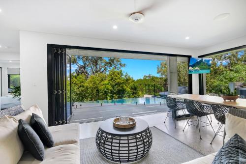 a living room with a couch and a table at Ohana - The Ultimate Family Pool Escape in Kewarra Beach