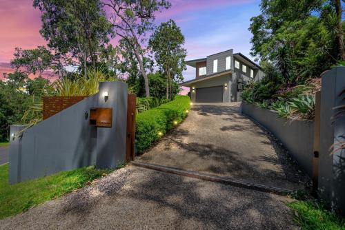 a driveway leading to a house with a fence at Ohana - The Ultimate Family Pool Escape in Kewarra Beach