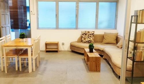 ein Wohnzimmer mit einem Sofa und einem Tisch in der Unterkunft Sunset Homestay - Backpacker Hostel Self Checkin in Kuching