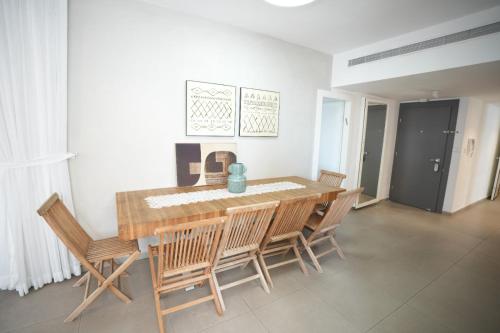 uma sala de jantar com uma mesa de madeira e cadeiras em Specious Pastoral And Attractive 5 Bedroom Apartment Center Hod Hasharon em Hod HaSharon