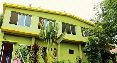 a green house with a cactus in front of it at Mookambigai Residency in Kodaikānāl