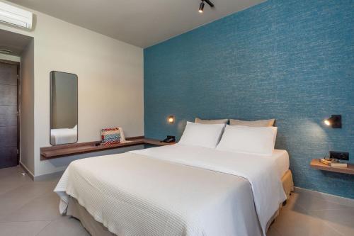 a bedroom with a large bed and a blue wall at Hotel Nafpaktos in Nafpaktos