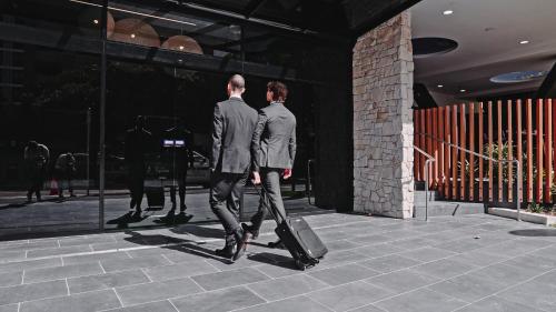 Due uomini che camminano per strada con i bagagli di 291 on King a Newcastle