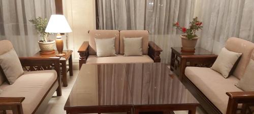 un soggiorno con sedie, tavolo e sedie di Hotel Kisa Thimphu a Thimphu