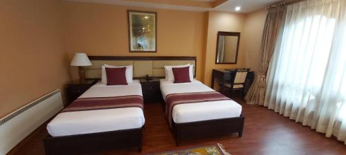 廷布的住宿－Hotel Kisa Thimphu，酒店客房设有两张床和窗户。