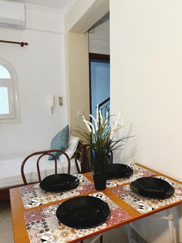a table with two black plates on top of it at Hermanos in Flogita