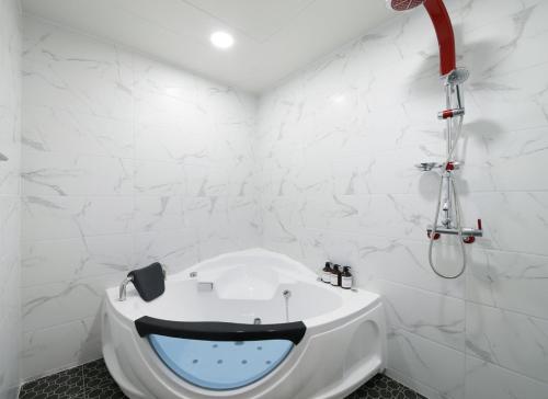 a bathroom with a bathtub with a face painted on it at WJ Hotel Pool House in Wonju