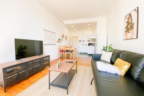 - un salon avec un canapé en cuir noir et une télévision à écran plat dans l'établissement #GP The Berri'Appart, à Grenoble