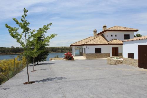 a house with a tree in the middle of a driveway at Casa Rural encantos de Orellana in Navalvillar de Pela