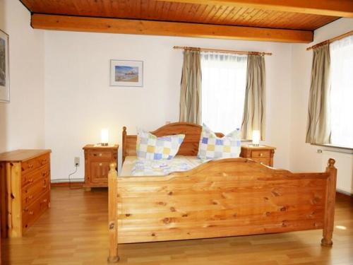 a bedroom with a wooden bed with two night stands at Lovely apartment in Apartment Lina in Pilsum