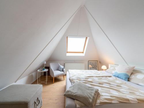 a attic bedroom with a bed and a window at Cozy Holiday Home in Hasselt Near By The Water in Hasselt