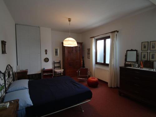 a bedroom with a bed and a desk and a window at Holiday Home near Lake Garda in Pastrengo