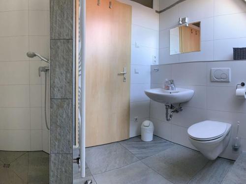 a bathroom with a shower and a toilet and a sink at Just before the cape, holiday home B in Putgarten