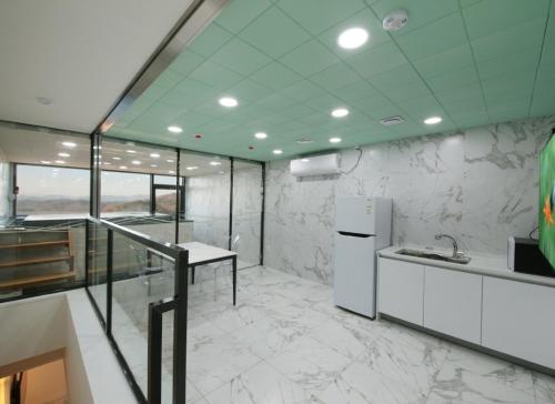 a kitchen with marble walls and a white refrigerator at WJ Hotel Pool House in Wonju