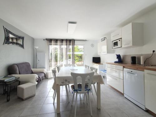 une cuisine et une salle à manger avec une table et des chaises dans l'établissement Maison de vacances à 300m de la plage à La Faute-sur-Mer - 6 pers, terrasse, parking, proche forêt - FR-1-476-167, à La Faute-sur-Mer