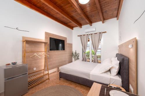 um quarto com uma cama e uma televisão em Eagle's Nest City Apartments em Aigio