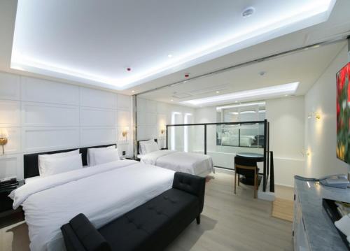 a hotel room with two beds and a desk at WJ Hotel Pool House in Wonju