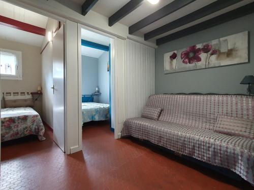 ein Zimmer mit einer Couch und einem Bett und einem Spiegel in der Unterkunft Villa calme proche plage pour 6 pers - FR-1-476-167 in La Faute-sur-Mer