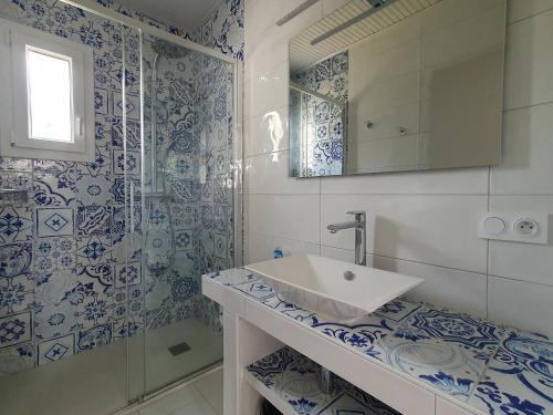 uma casa de banho azul e branca com um lavatório e um chuveiro em Maison La Faute-sur-Mer, 3 pièces, 4 personnes - FR-1-476-187 em La Faute-sur-Mer