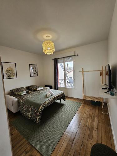 une chambre avec un lit, une fenêtre et une télévision dans l'établissement Chambre verte proche de stade de France, à Pierrefitte-sur-Seine