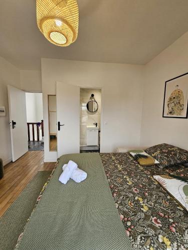 - une chambre avec 2 serviettes sur un grand lit dans l'établissement Chambre verte proche de stade de France, à Pierrefitte-sur-Seine