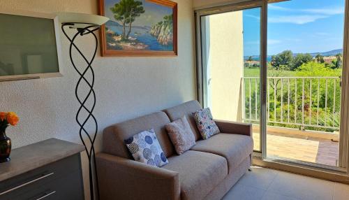 - un salon avec un canapé en face d'une fenêtre dans l'établissement T2 ensoleillé, vue mer et champ, climatisé, à Carqueiranne