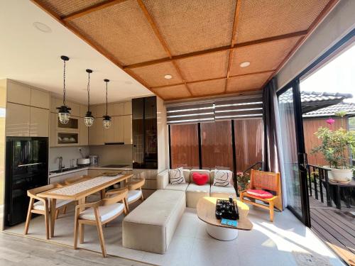 a kitchen and living room with a wooden ceiling at Ogimi Villas Bảo Lộc in Blao Srê
