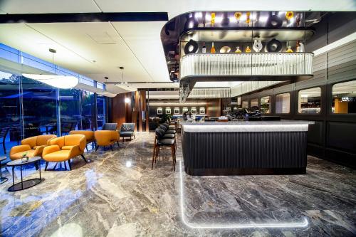 a bar in a restaurant with orange chairs at Nanjing Fanyue Plaza Intercity Hotel in Nanjing