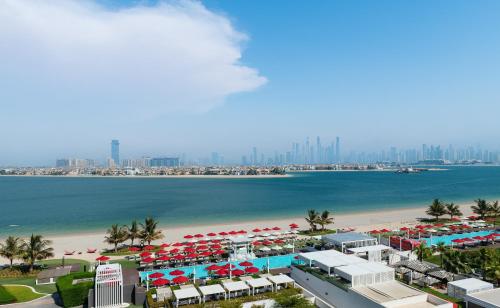 an aerial view of a beach with umbrellas at Th8 Palm Dubai Beach Resort Vignette Collection, an IHG hotel in Dubai