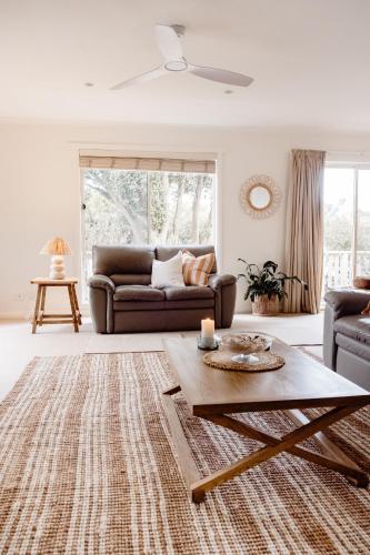 a living room with a couch and a table at Banksia Beach House in Port Fairy