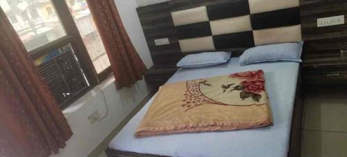 a bed with a blanket and pillows on it at Hotel Galaxy in Rudraprayāg