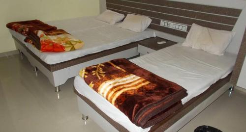 two twin beds in a room at Hotel Galaxy in Rudraprayāg