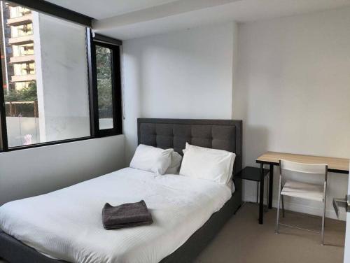 um quarto com uma cama e uma mesa com uma cadeira em 1Min to SouthernCross, Free,Tram,Pool,Gym,L606 em Melbourne