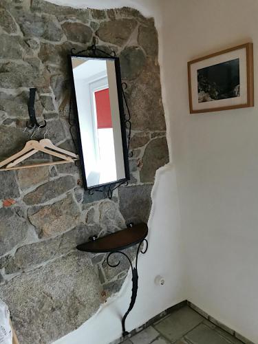 a mirror on a stone wall next to a chair at Ferienhaus Emilia in Wilthen
