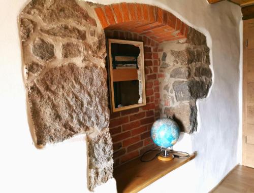a room with a brick wall and a globe on a shelf at Ferienhaus Emilia in Wilthen