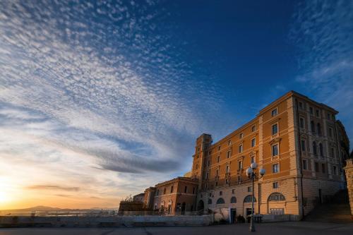 a building with a cloudy sky behind it at Palazzo Boyl 1840 in Cagliari