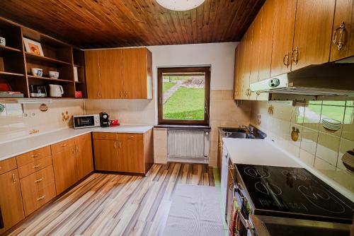 kuchnia z drewnianymi szafkami i oknem w obiekcie Holiday Home Vila Kopriva w mieście Gozd Martuljek