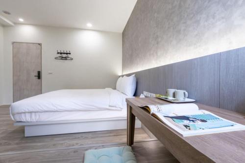 um quarto de hotel com uma cama e uma mesa com um livro em 礁溪亞都溫泉旅店 Newly Renovated em Jiaoxi