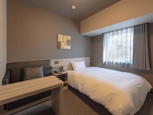 Hotel Route Inn Owariseto Ekimae tesisinde bir odada yatak veya yataklar