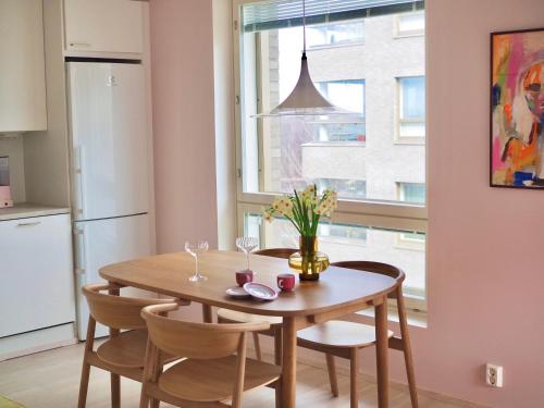 uma cozinha com mesa e cadeiras e uma janela em Candy-Colored Two-Room Condo with Sweet views em Helsinque