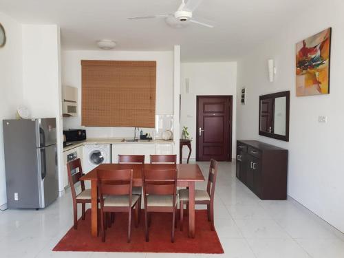 een keuken en eetkamer met een tafel en stoelen bij Meadows Living 2 BR Apartment near Mount Beach in Karagampitiya