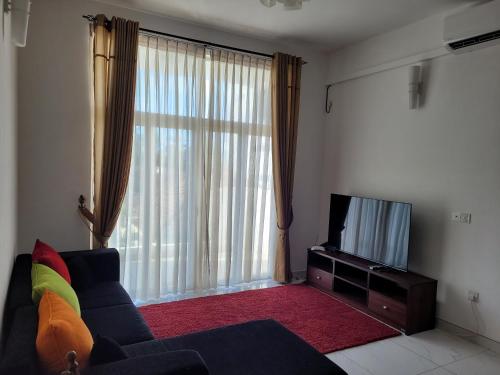 een woonkamer met een bank en een televisie bij Meadows Living 2 BR Apartment near Mount Beach in Karagampitiya