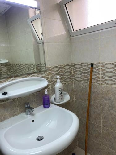 uma casa de banho com um lavatório e um espelho em Studio Appartment in Building em Ras al-Khaimah