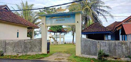 Karang Besi Losmen في Biha: بوابة إلى منزل مع المحيط في الخلفية