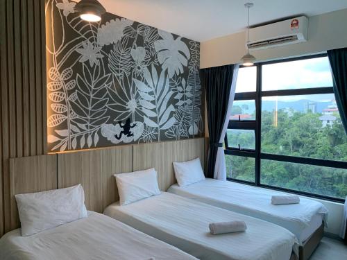 two beds in a room with a window at Jesselton QUAY PICKNSTAY 拾旅 near gaya street near jesslton point near suria sabah in Kota Kinabalu