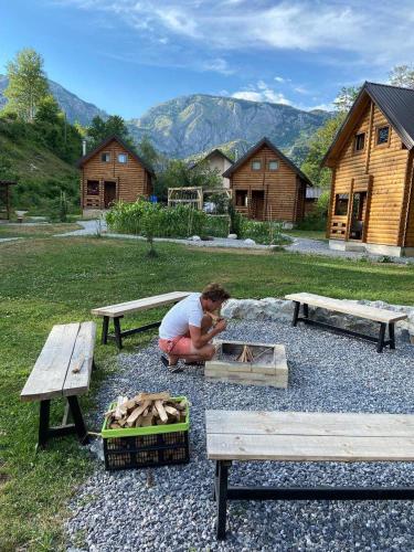 a woman kneeling on the ground next to two benches at Camp Lipovo in Kolašin