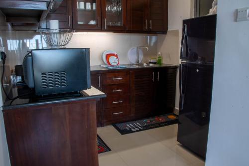 a kitchen with a counter with a microwave and a refrigerator at Lovish luxury villa in Colombo