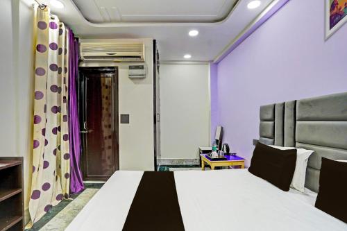 una camera da letto con un grande letto con pareti viola di OYO Flagship Starx Inn a Nuova Delhi